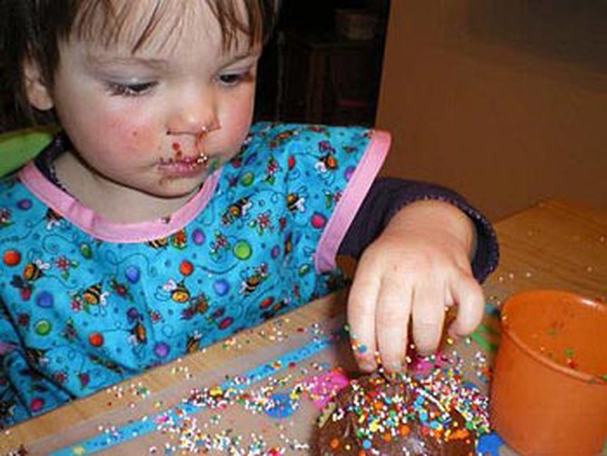 Sheila's daughter decorates a cupcake.