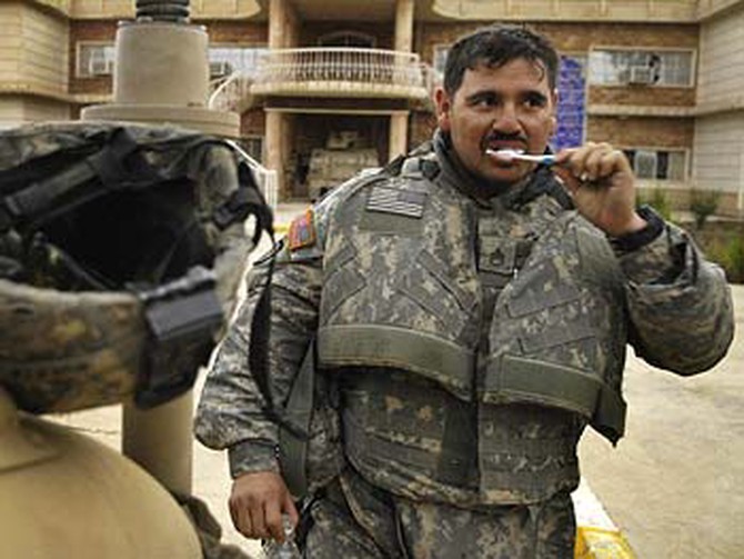 A soldier brushes his teeth.