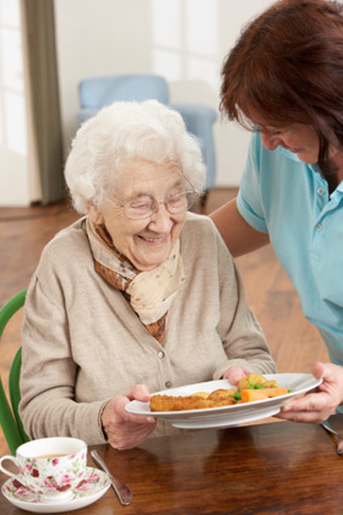 Serving meals to a senior woman