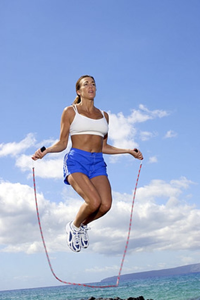 Woman jumping rope in sports bra and athletic shorts