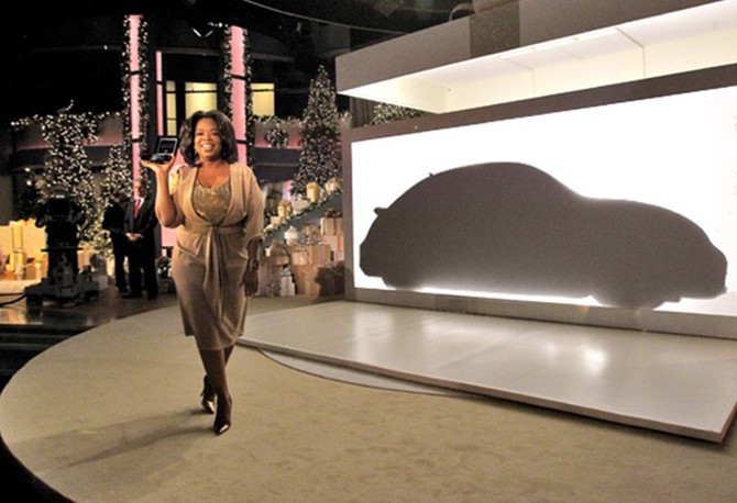 Oprah Winfrey in front of silhouette of Volkswagen Beetle