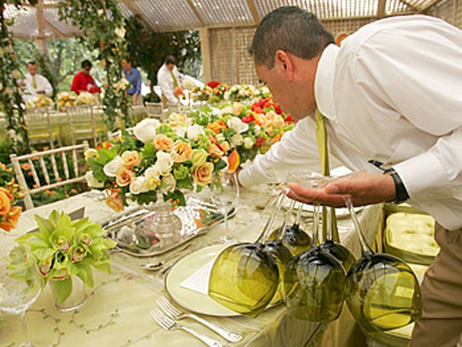 A staff member helps set the table.
