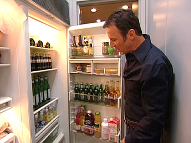 Colin Cowie checks his refrigerator for beverages.