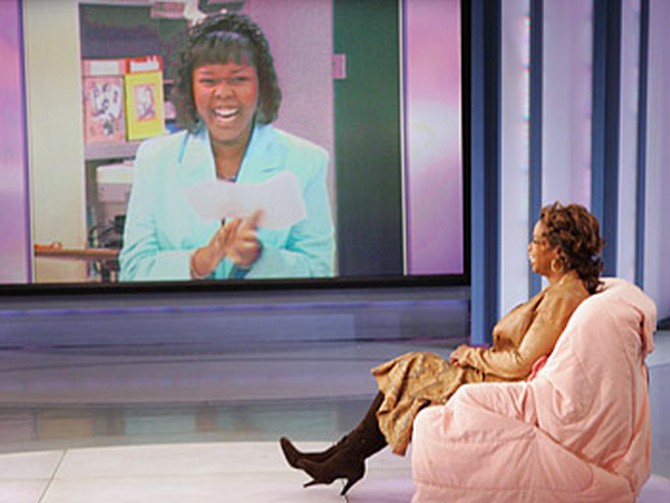 Oprah finally takes a seat in the chair Mrs. Adeniyi reserved for her.