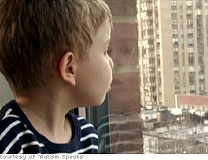 An autistic child stares out of a window.