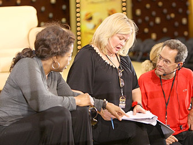 Oprah consults with an executive producer and stage manager.