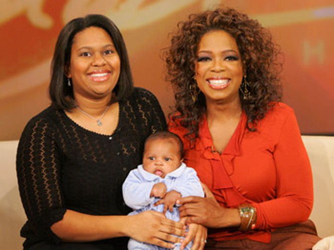 Oprah poses with a mom and her baby.