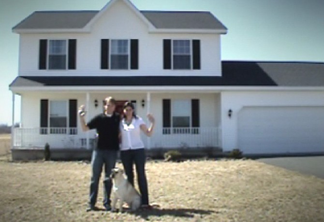 Carmela and her husband in front of their new house