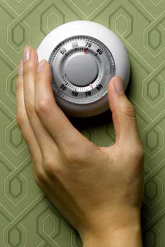 Hand adjusting a thermostat