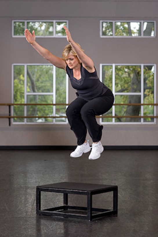 woman doing box jumps at the gym