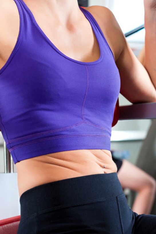 woman twisting abdominals on gym machine