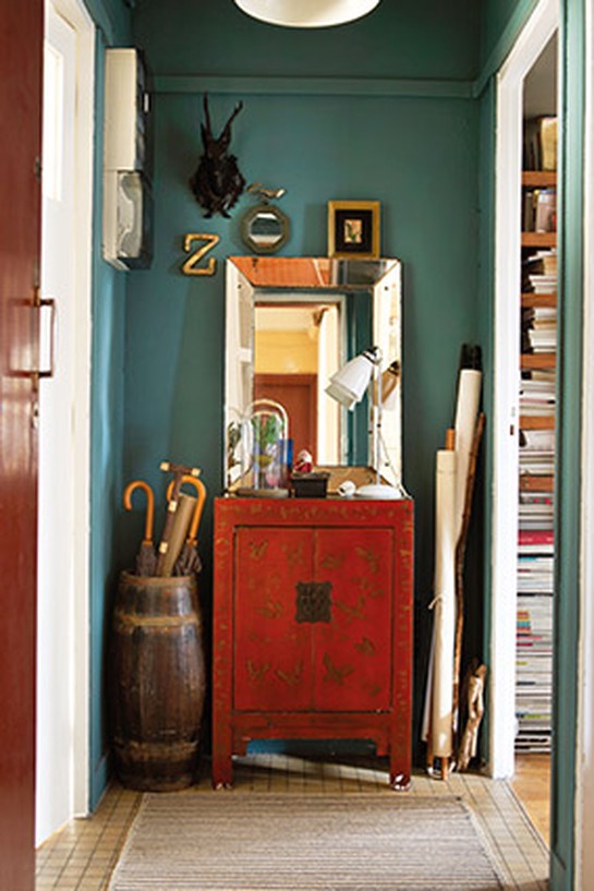 Teal/emerald entryway with a red cabinet and distressed mirror