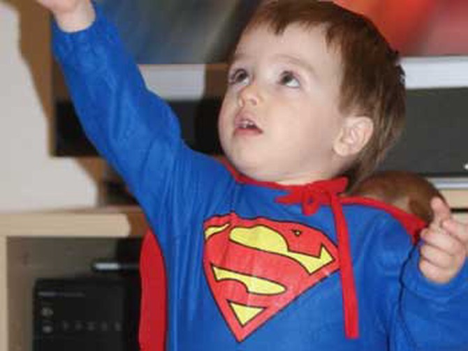 A little boy dressed as superman