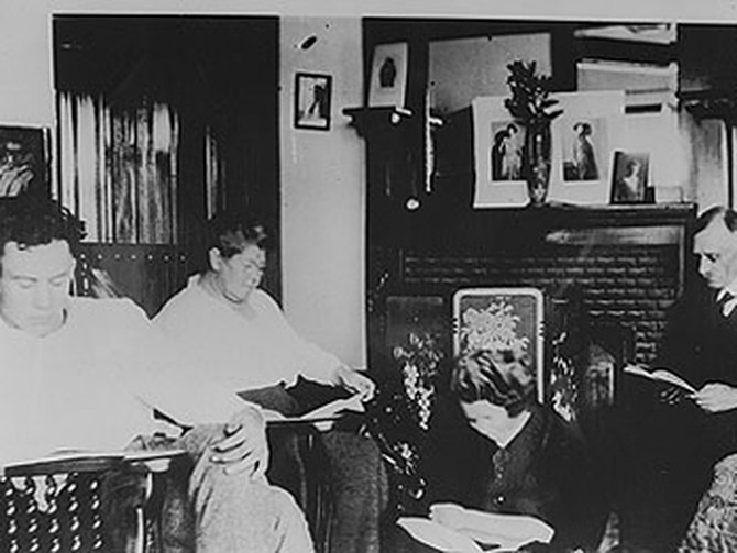 Steinbeck as a young man reading with his family.
