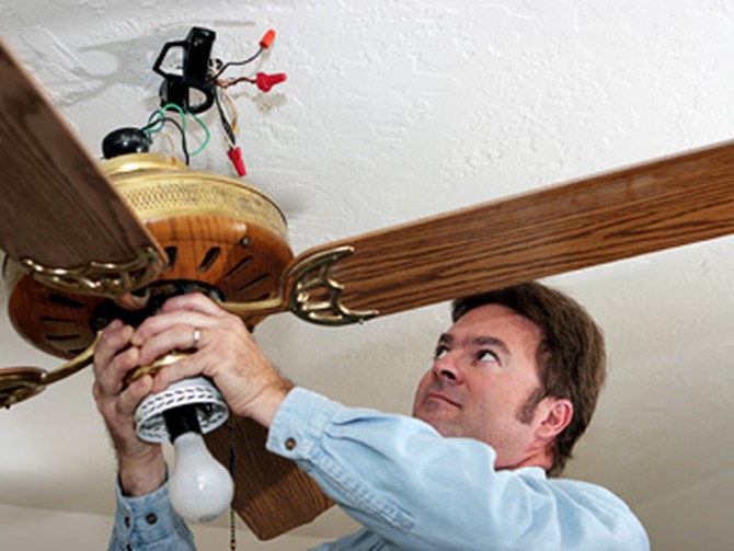 Man repairing a ceiling fan