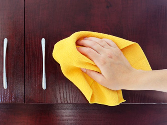 Woman's hand cleaning a cabinet