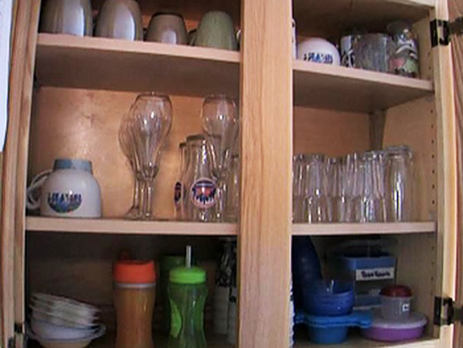 Organized glasses in a kitchen cabinet.