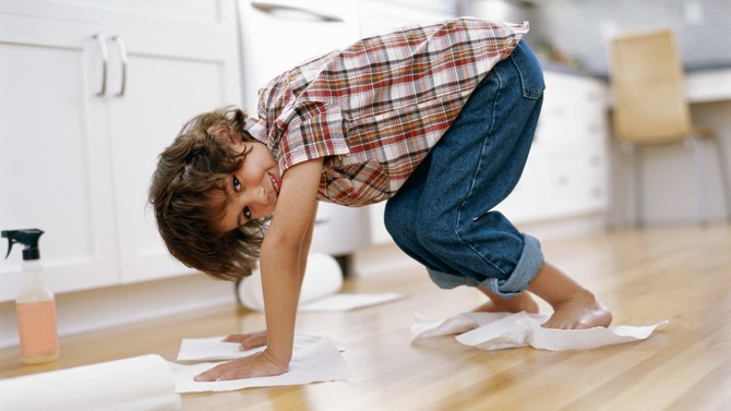 Boy wiping floor with paper towels