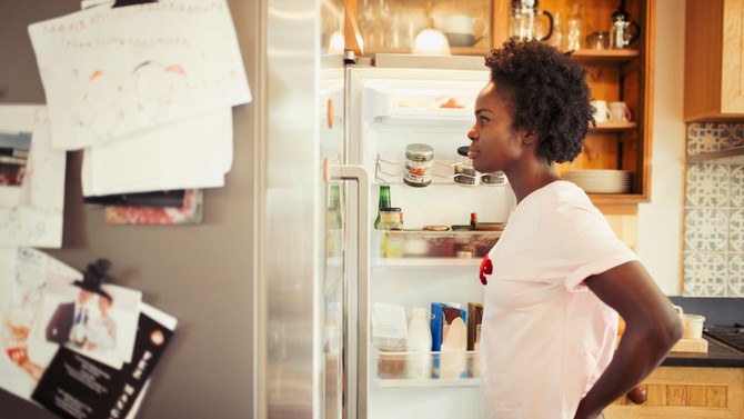 Woman assessing the contents of her refrigerator