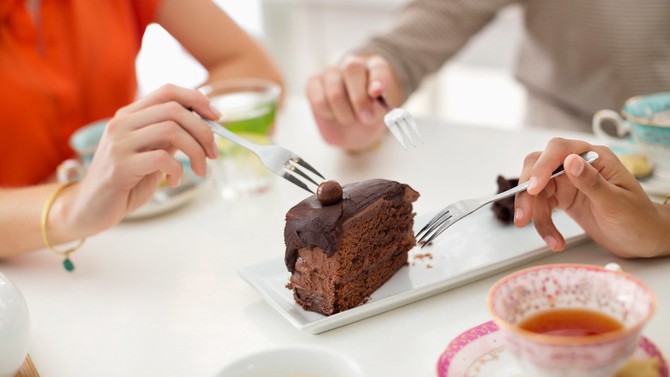 Women sharing a cake slice