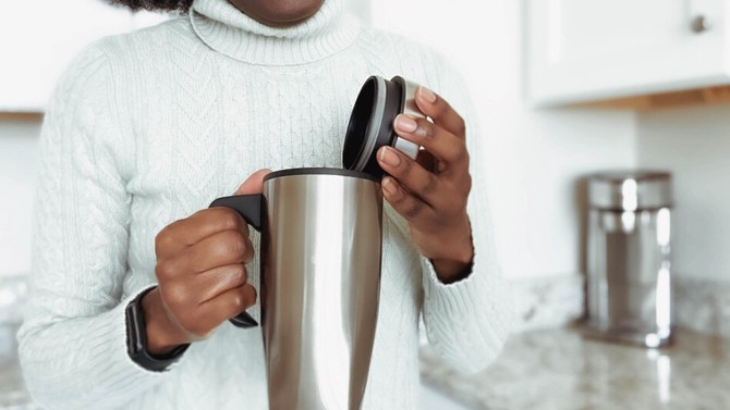 woman with stainless steel coffee thermos