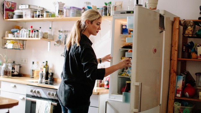 woman standing in front of an open refrigerator