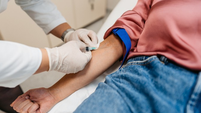 doctor drawing blood from a patient's arm