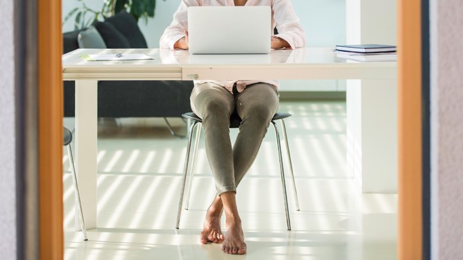 Woman working barefoot in her office
