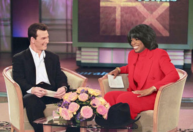 Oprah on her show in the red suit