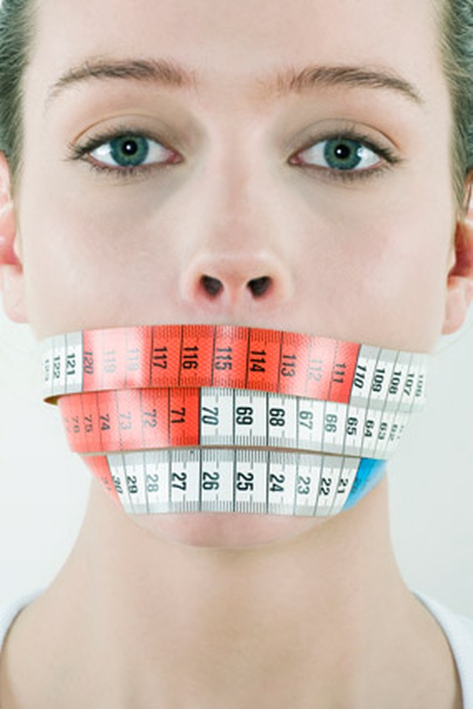 Woman with measuring tape around her mouth