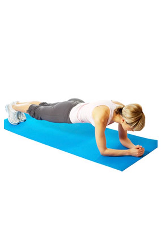 Woman doing plank exercise on mat