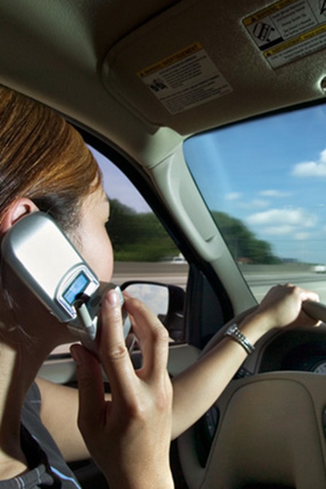 Woman driving and talking on cell phone