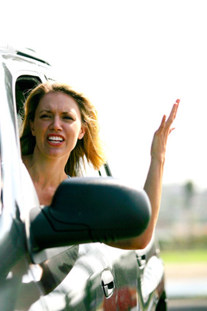 Frustrated woman leaning out of car window