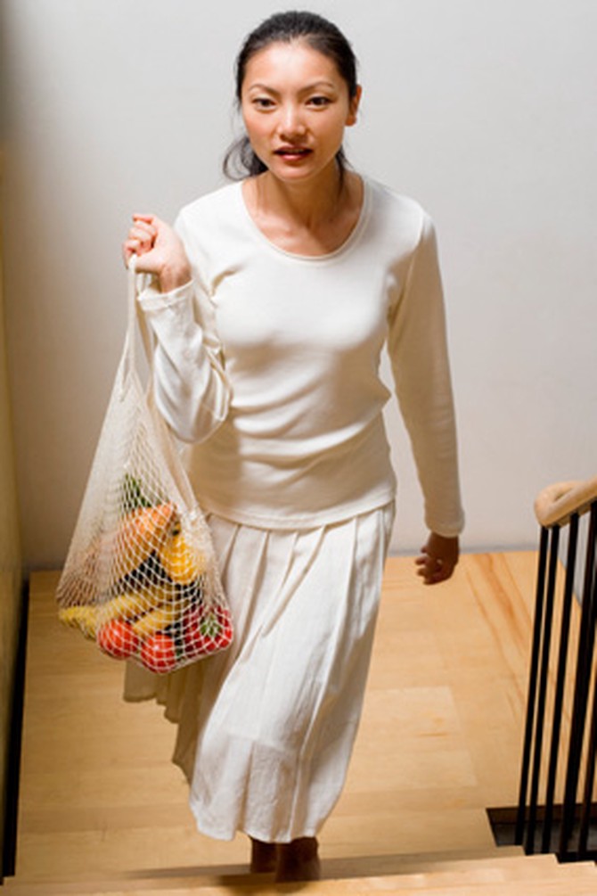 woman walking up stairs with groceries