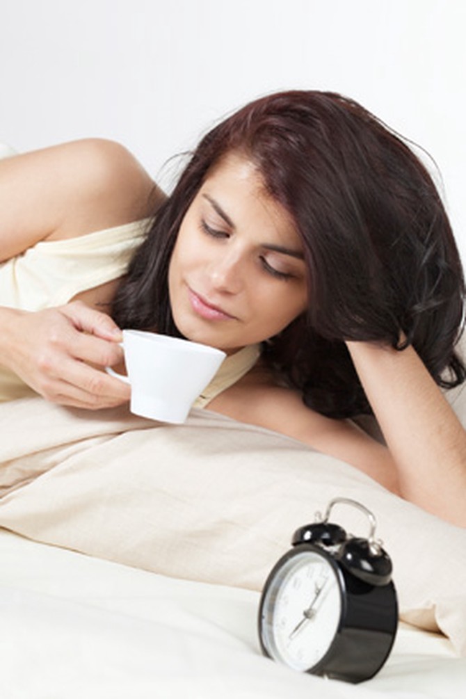 Woman drinking coffee in bed