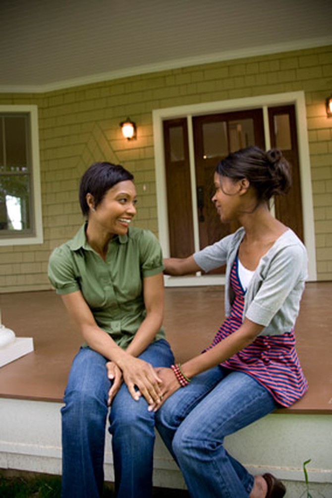 Two women talking together on porch