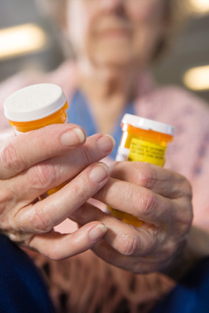 Older woman with prescription medication bottles
