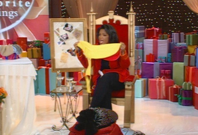 Oprah Winfrey sits in throne holding yellow dog slicker
