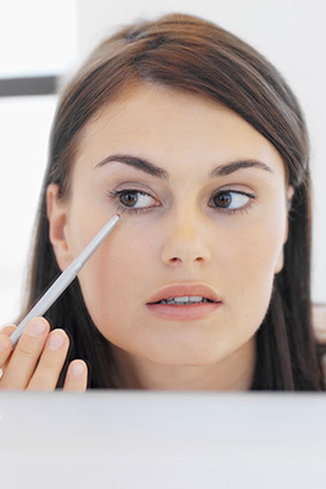 Woman applying eyeliner to lower lashes