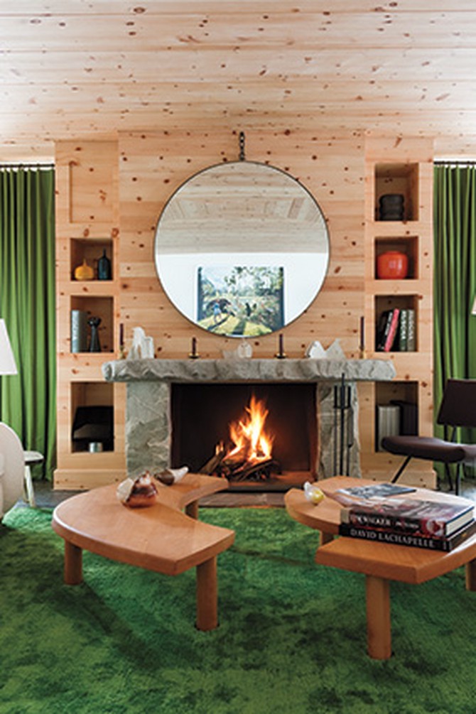 A modern-meets-rustic living room featuring wood-paneled walls and emerald curtains