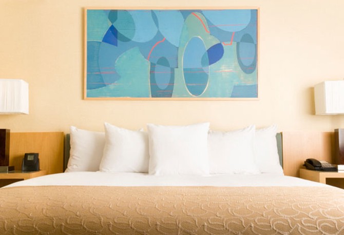 Turquoise painting above neutral bed