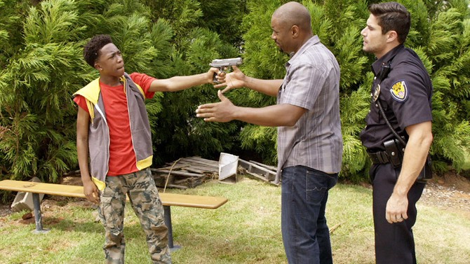 Young actor pointing gun at Malik Whitfield and Joel Rush