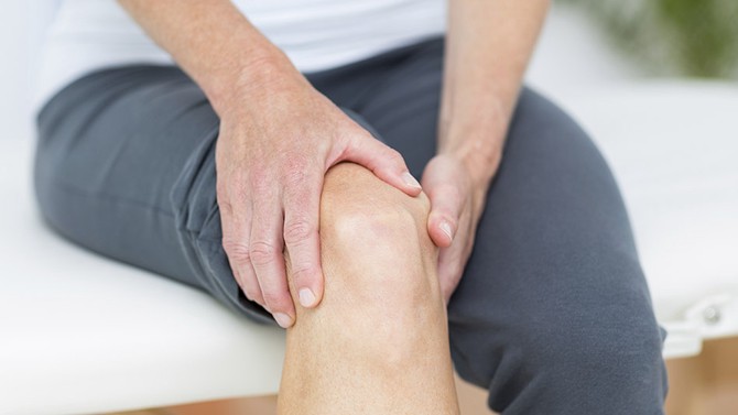 Woman holding knee in pain