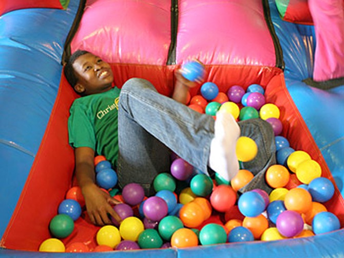 A child enjoys playing at the Christmas carnival.