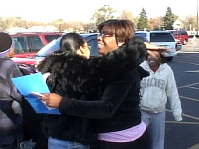 Lenita gets a big hug from a stranger after surprising her with a gift of $250.