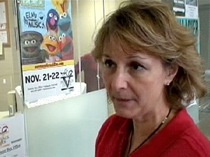 Mary Schmit in front of a poster for 'Sesame Street Live'