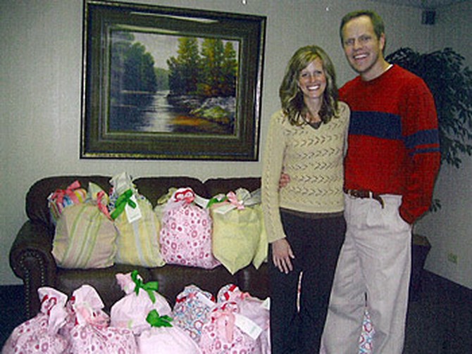 Mindy and her husband with the 'Pillows of Love' created for birth mothers of adopted children