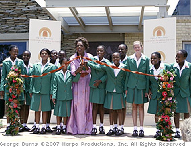 Oprah and her girls cut the ribbon to open the academy.
