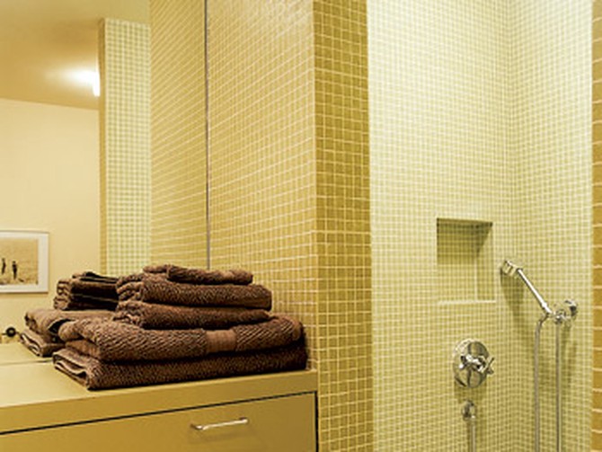 Glossy tiles keep this windowless bathroom bright.