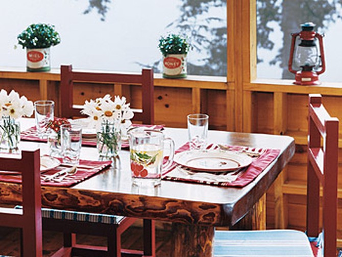 The family uses the cabin's second-floor porch for dining and playing board games.